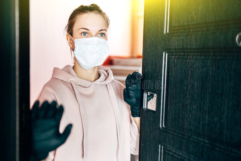 Girl in the respirator opens the front door to go outside. The girl in the respirator opens the front door to go outside royalty free stock photo