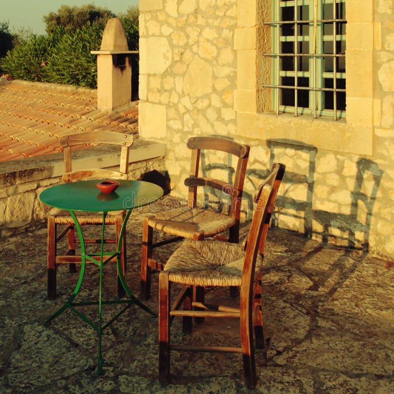 Greek country outdoor restaurant on roof terrace, Crete, Greece. Square vintage toned image stock photo