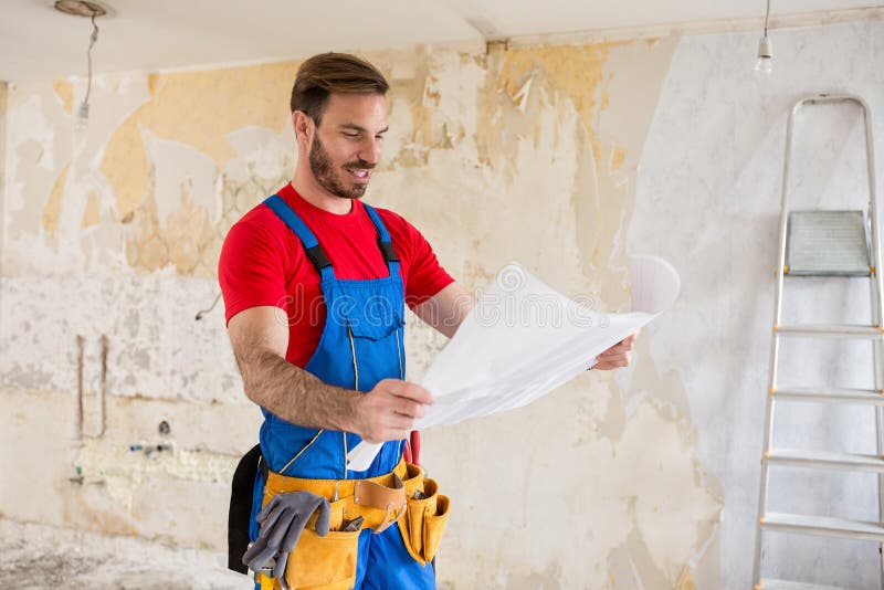 Handyman watchig blueprnts of home renovations. Success job stock photos