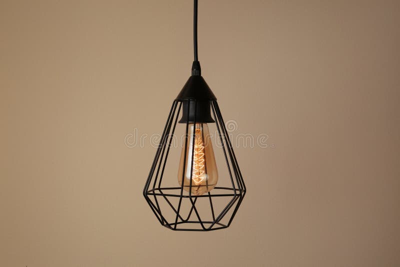 Hanging lamp bulb in chandelier. Against beige background stock photos
