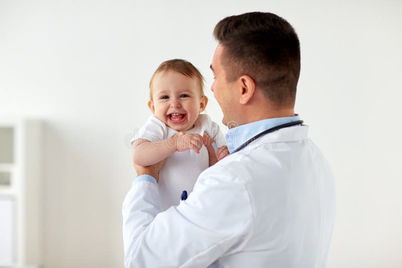 Happy doctor or pediatrician with baby at clinic royalty free stock image