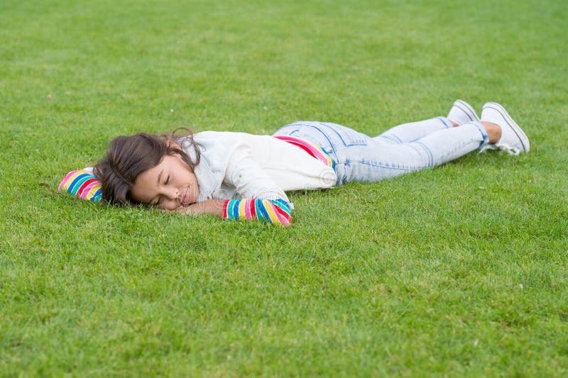 Healthy sleep on fresh air. happy child lying on grass. dream. small girl relax on green grass. spring is here. human. And nature concept. kid enjoy summer stock photo