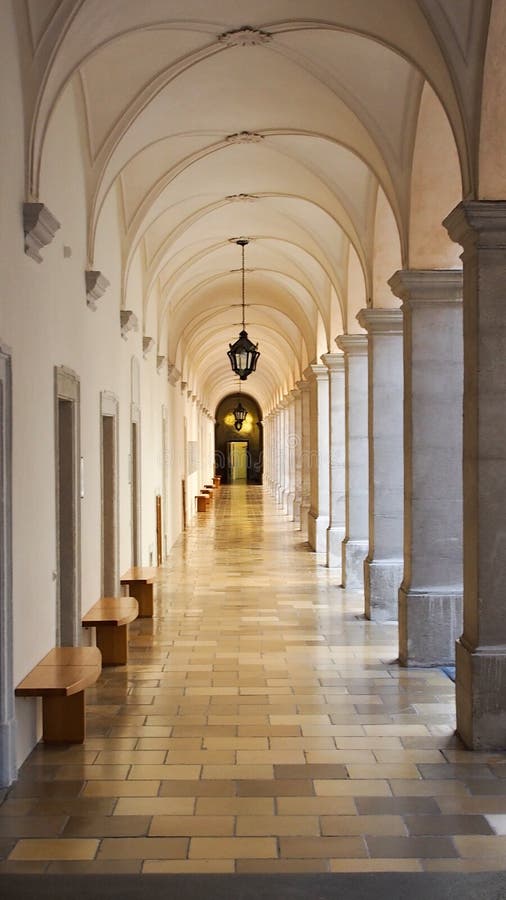Looking down historic and ancient hallway with pillars along the sides stock image