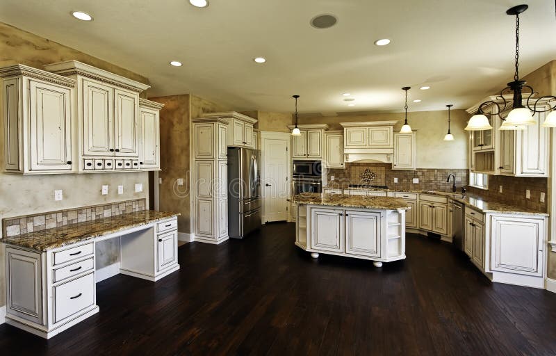 Huge new kitchen and dining room. New model home with huge white kitchen cabinetry and dining room with hardwood floors royalty free stock image