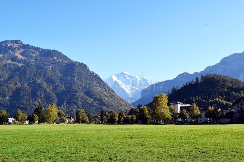 Interlaken, Switzerland, Immense lawn garden surrounded by giant mountains. An immense lawn garden and the mountains surrounding Interlaken in the background.In stock photography