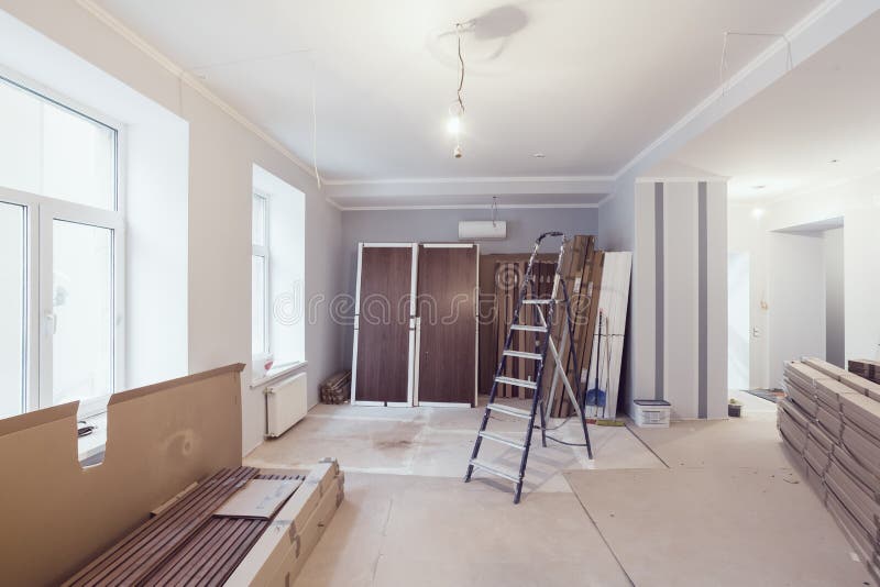 Interior of apartment during construction, remodeling, renovation, extension, restoration and reconstruction - ladde. R and construction materials in the room stock image