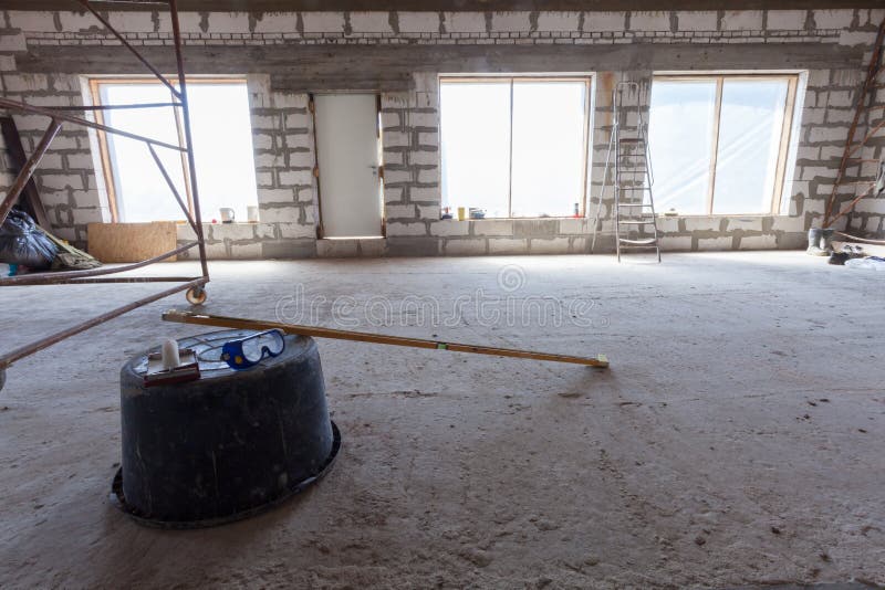 Interior of apartment with ladder during under renovation, remodeling and construction Plastic basin with protect glasses and lev royalty free stock image