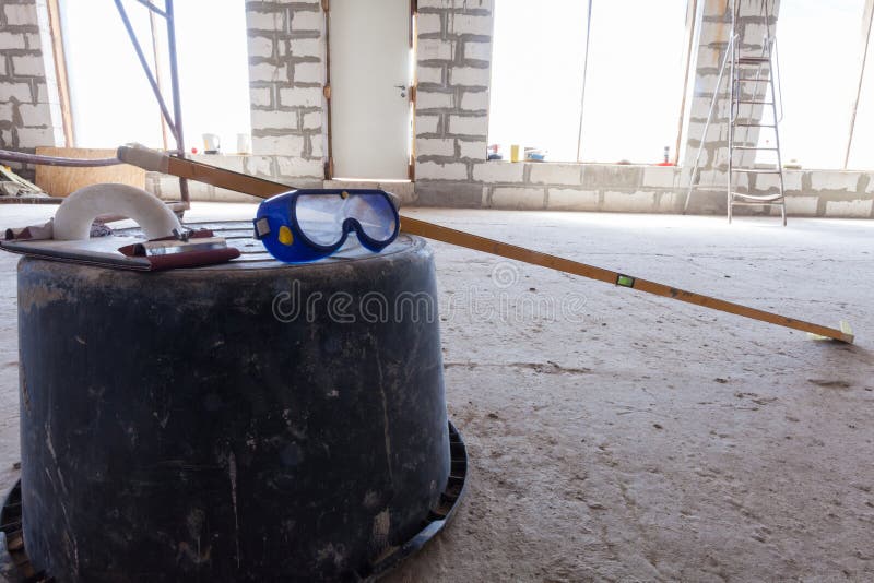 Interior of apartment with ladder during under renovation, remodeling and construction Plastic basin with protect glasses and leve stock photos