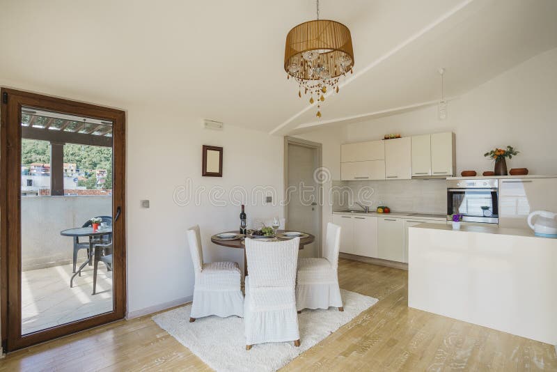 Interior of light kitchen in a villa. Interior of light spacious kitchen with large panoramic windows in a luxury villa stock photo