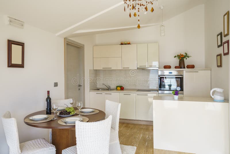 Interior of light spacious kitchen in a villa. Interior of light spacious kitchen with large panoramic windows in a luxury villa royalty free stock photography