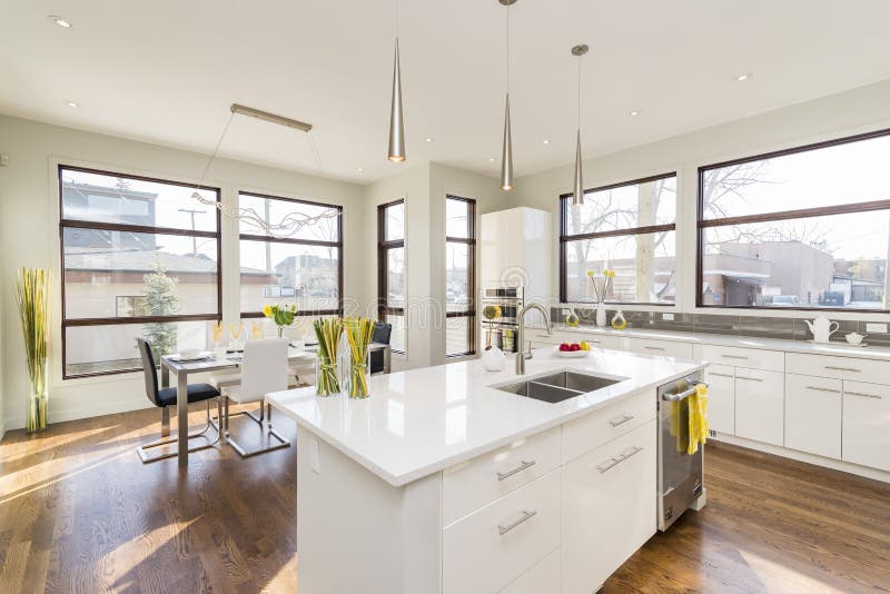 Interior shot of a modern house kitchen with large windows. An interior shot of a modern house kitchen with large windows stock images