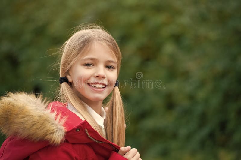 Kid girl enjoy fresh autumnal air. Child blonde long hair warm jacket nature background. Girl charming smile coat enjoy. Fall park. Child wear fashionable coat royalty free stock photography