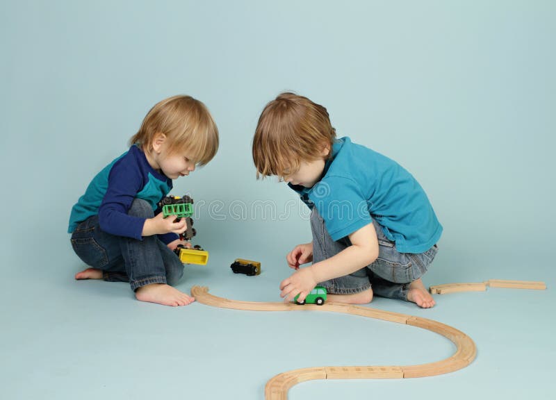 Kids playing with toy trains stock images