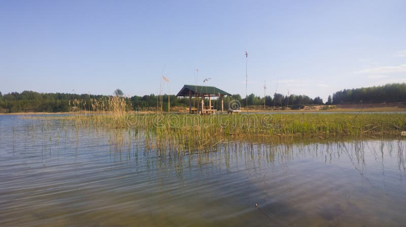 A large blue lake. Summer day. Gazebo on the shore stock photos