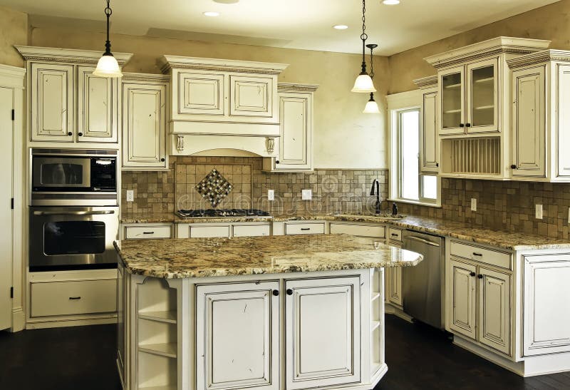 Large new modern white kitchen. Huge new kitchen with custom distressed white cabinetry, center island and hardwood floors royalty free stock photo