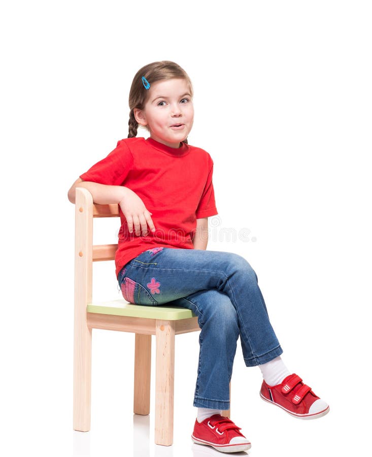Little girl wearing red t-short and posing on chair stock photography