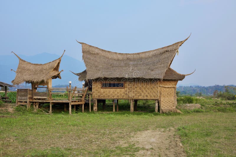 Local architectural house with unique roof design and green in foreground mountain in background. In northern region of Thailand royalty free stock photography