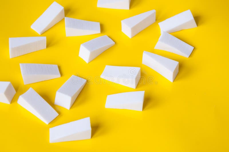 Lots of white triangular sponges on a yellow background royalty free stock photo
