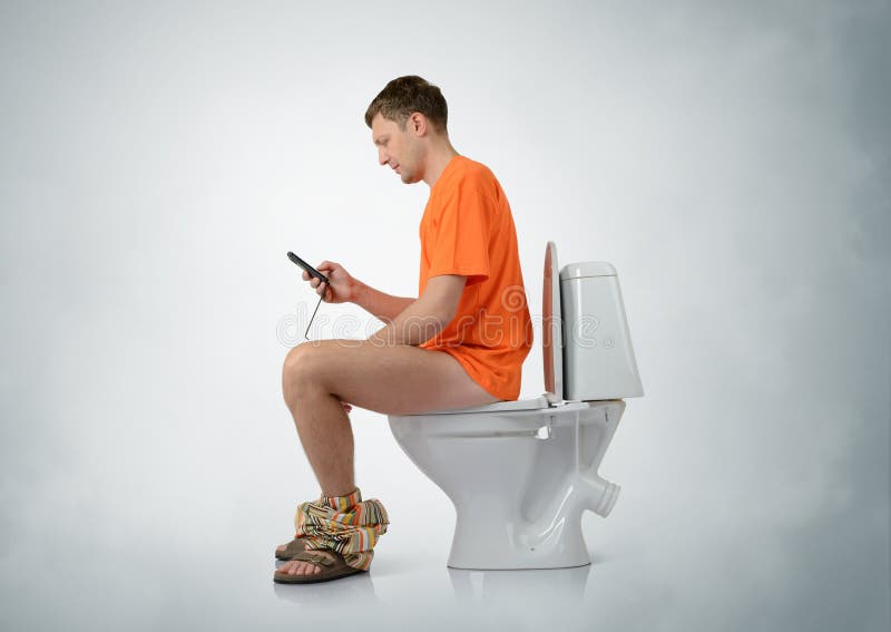 Man with smartphone sitting on the toilet royalty free stock photos