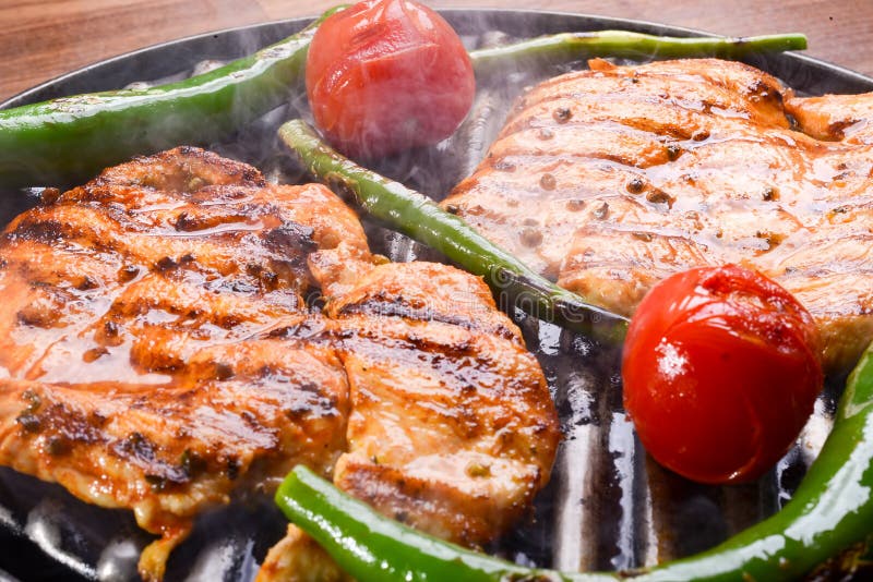 Marinated grilled healthy chicken breasts cooked on a summer BBQ and served with fresh herbs.  royalty free stock photo