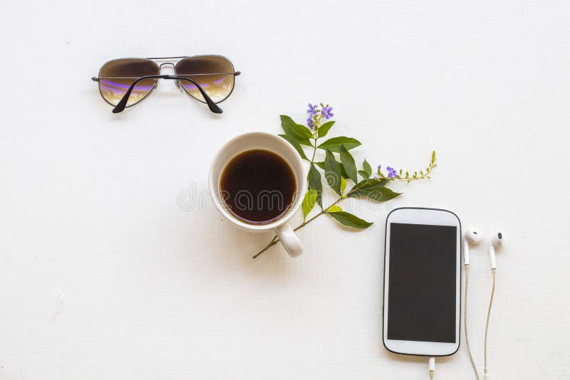 Mobile phone, hot coffee espresso and sunglasses of lifestyle at office arrangement flat lay style. On background white stock photo