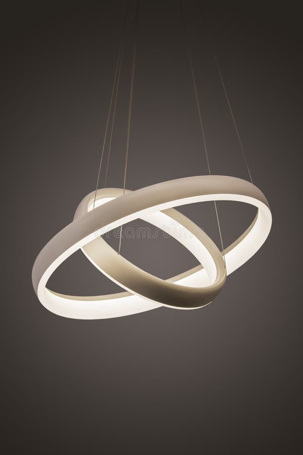 Modern led pendant light lamp illuminated, fashionable designer chandelier in the form of rings.  royalty free stock image
