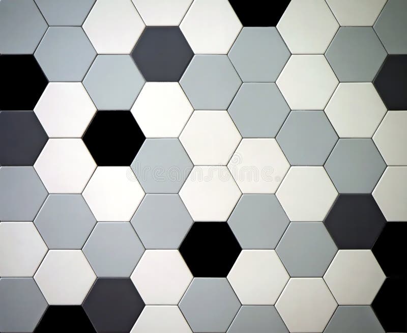 Modern tiled floor with hexagonal tiles. Colors are black,white, light and dark gray randomly arranged stock photography