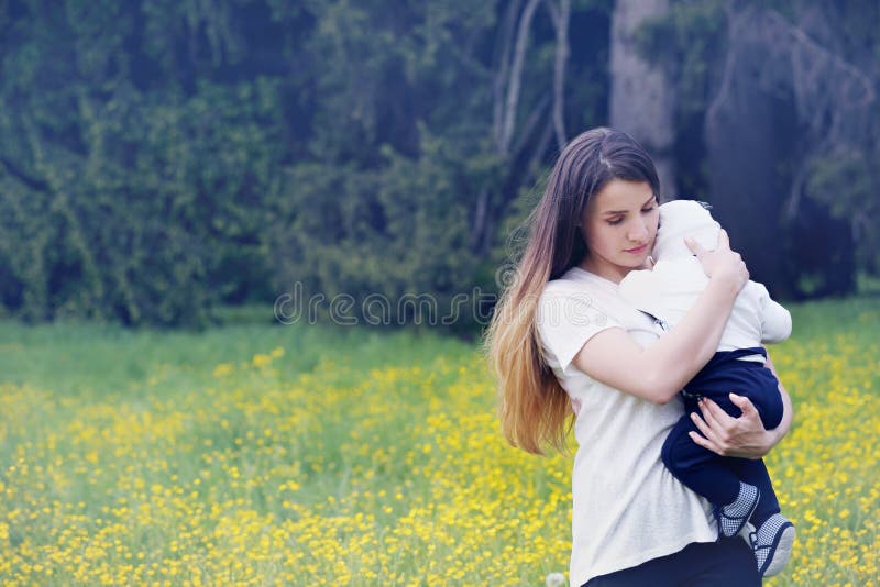 Mother embracing her child. Mother tenderly embracing her child in nature stock photography