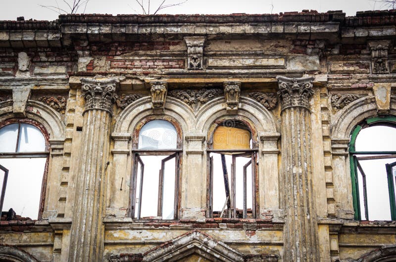 Old destroyed building. Beautiful old windows in ruined mansion. Destruction building. Dramatic background stock image