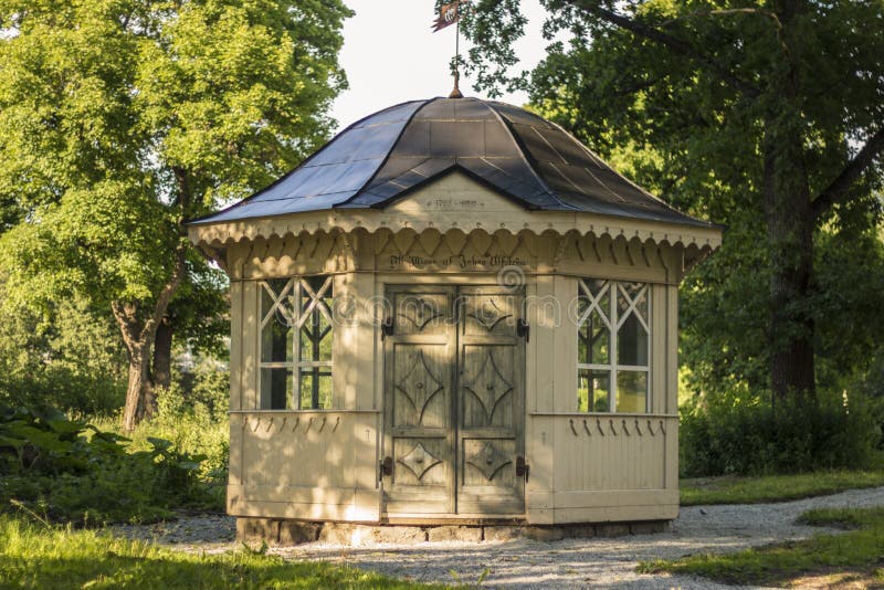 Old Gazebo in a summer park on a hot day, yellow colored and with black roof royalty free stock photography