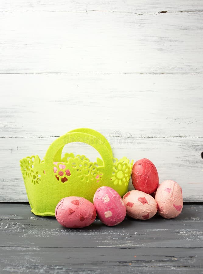 Painted Easter Eggs in decorated green basket on wooden table. stock images