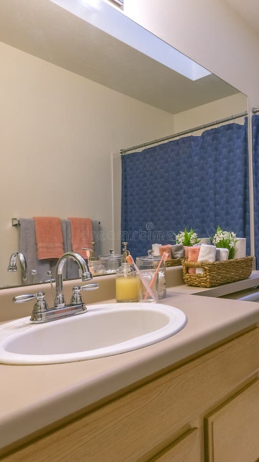Panorama Interior of a small and cozy bathroom with a single vanity unit and toilet. The blue shower curtain conceals the shower and bathtub royalty free stock photography