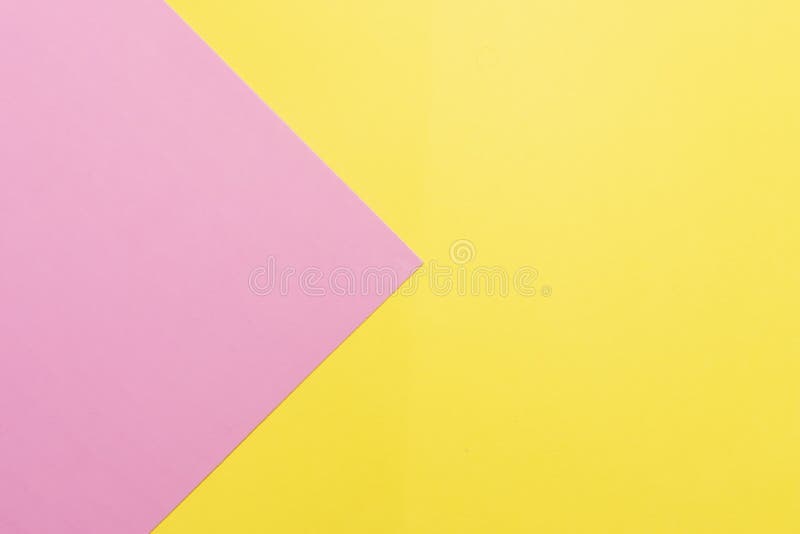 Pink and yellow two colours paper geometrical triangular background. Pink triangle on yellow background royalty free stock photography