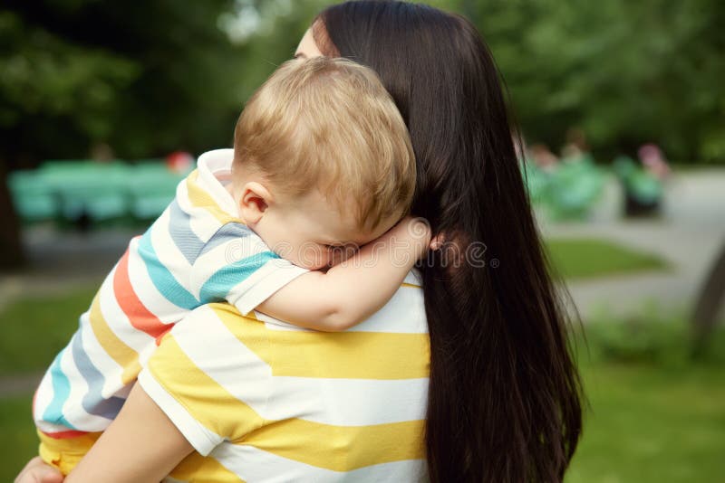 Portrait of mother and son. Outdoor portrait of mother and son. child and mom walk in the summer park. sad crying baby royalty free stock image