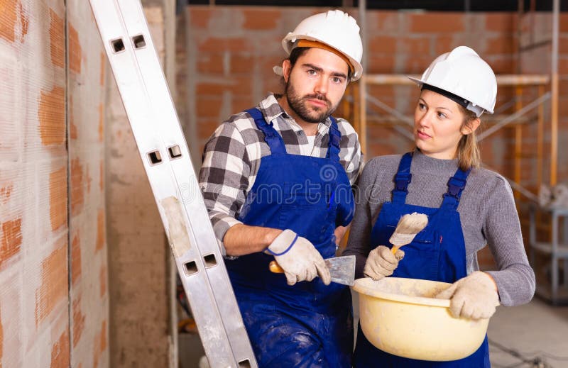 Portrait of two painters inside a cottage under construction. High quality photo royalty free stock image