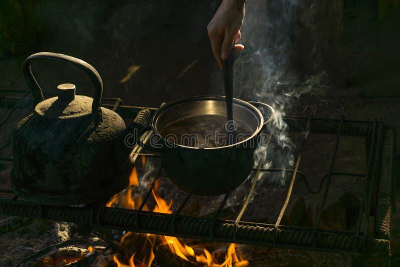 Pot and kettle on a portable hearth made of metal rods in a nomad`s dwelling royalty free stock images Pot and kettle on a portable hearth made of metal rods in a nomad`s dwelling royalty free stock images