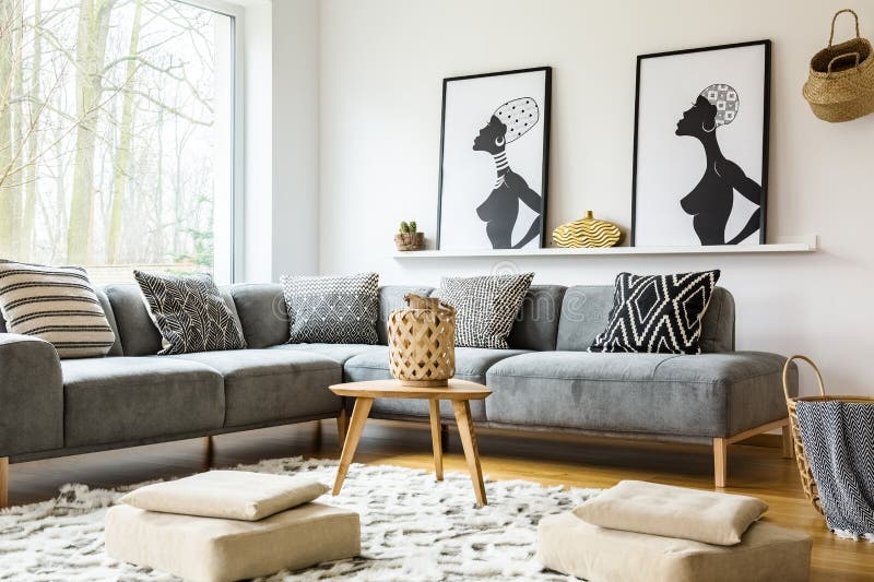 Poufs on carpet in bright african living room interior with grey stock images