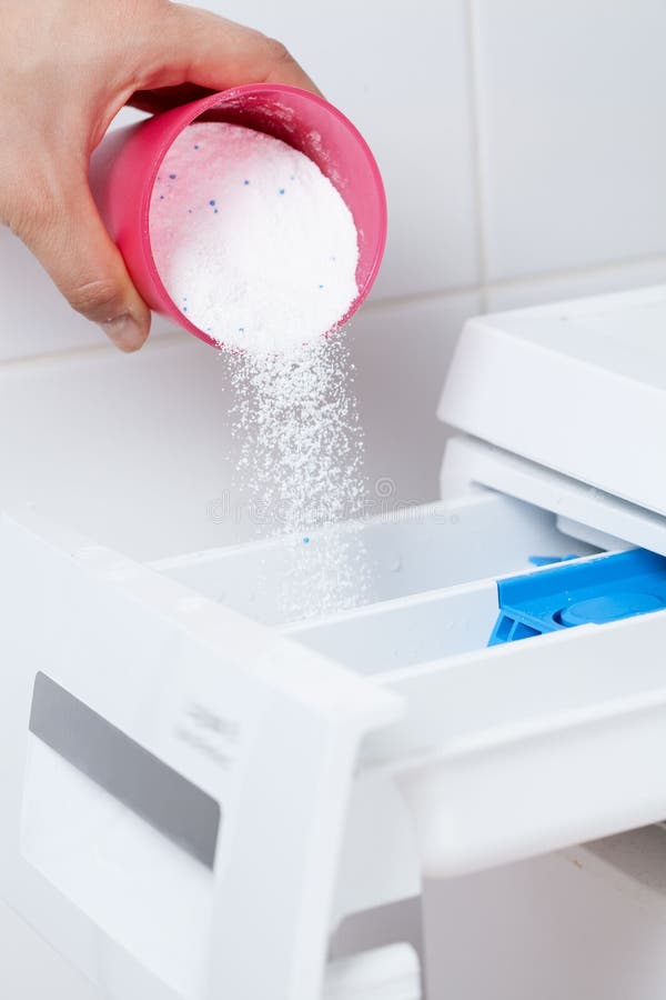 Pouring washing powder into the washing machine stock photo