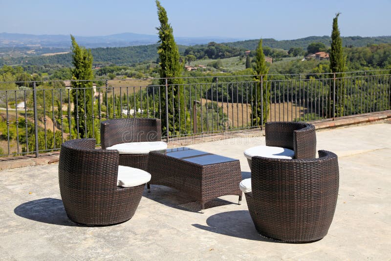 Rattan table and armchairs on country terrace, Tuscany, Italy. Beautiful landscape with rattan table and armchairs on country terrace, Tuscany, Italy stock images