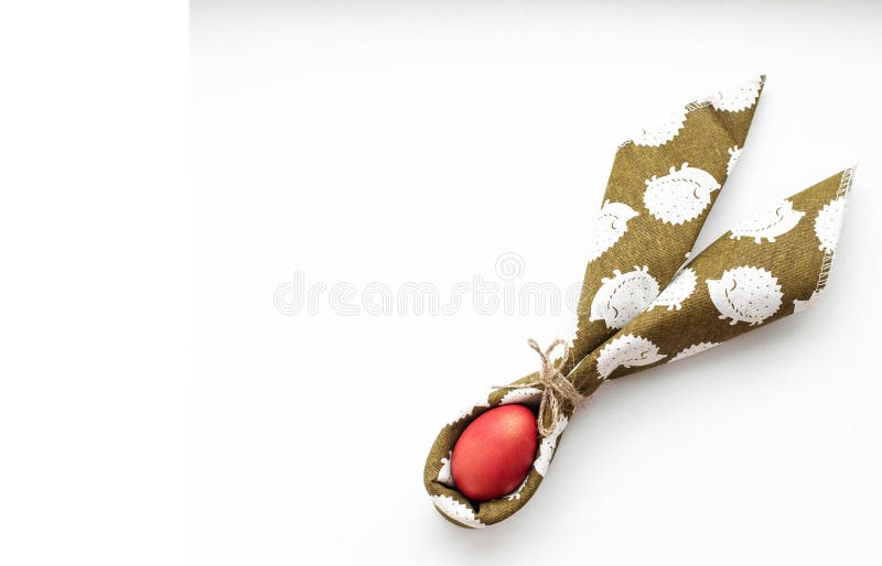 Red Easter egg in a green napkin tied with natural thread stock photos