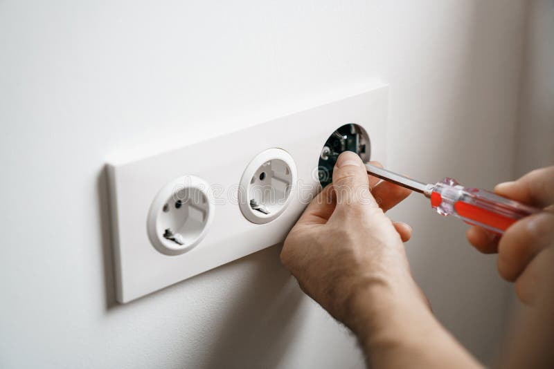 Repair electricity socket man with bare hands. Improper safety or repair of the electrical outlet stock images
