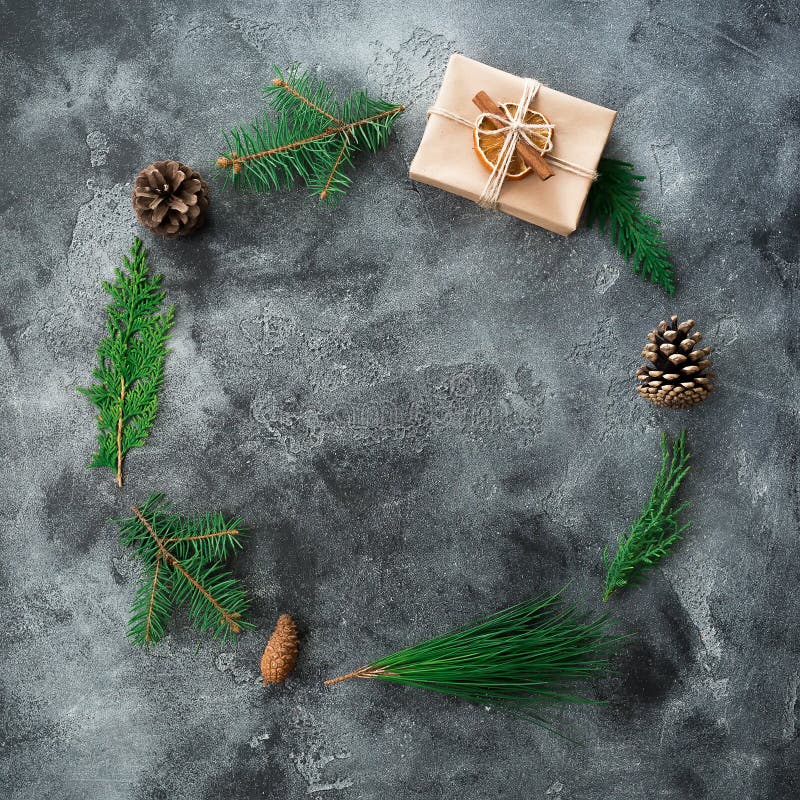 Round frame of Christmas gift box, winter tree branch and pine cones on dark background. New year composition. Flat lay. Top view royalty free stock images Round frame of Christmas gift box, winter tree branch and pine cones on dark background. New year composition. Flat lay. Top view royalty free stock images