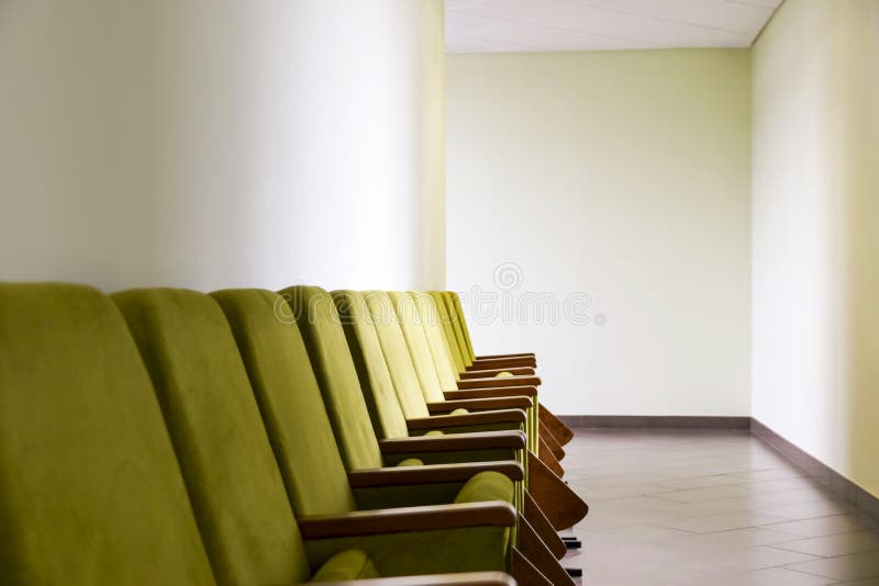 Row of Green Auditorium Seating Soft Chairs with Writing Pads Placed along the Wall in the Hallway. Business or Political Event, stock photos