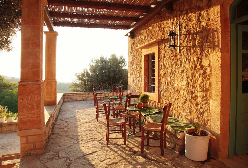 Rural greek country outdoor restaurant on pergola terrace with e. Mpty table, Crete, Greece. Sunset light stock photos
