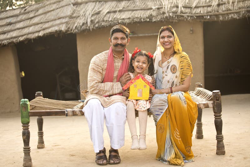 Rural Indian family holding dream house model stock images