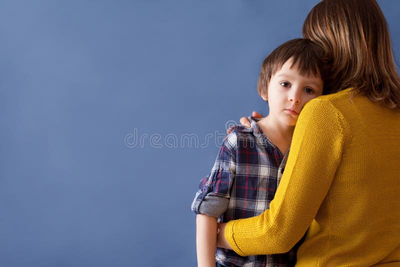 Sad little child, boy, hugging his mother at home. Image, copy space. Family concept stock image