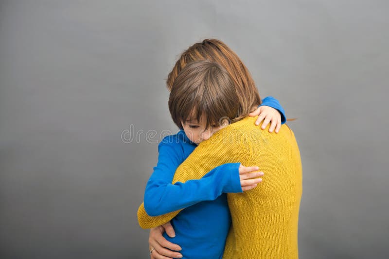 Sad little child, boy, hugging his mother at home, isolated image. Copy space. Family concept stock photo