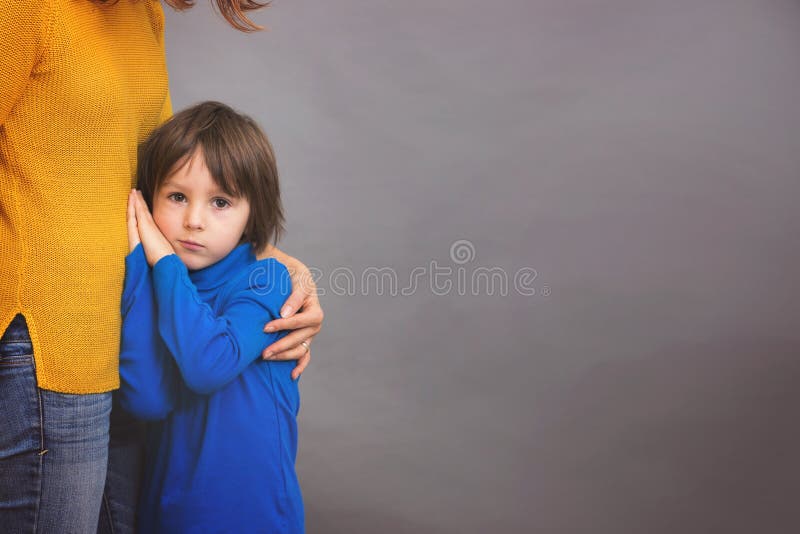 Sad little child, boy, hugging his mother at home, isolated image. Copy space. Family concept royalty free stock photography