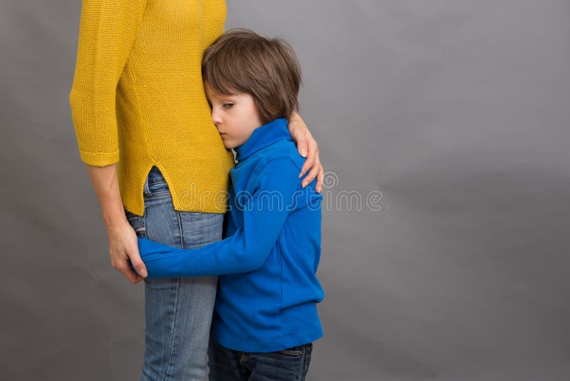 Sad little child, boy, hugging his mother at home, isolated image. Copy space. Family concept royalty free stock photography