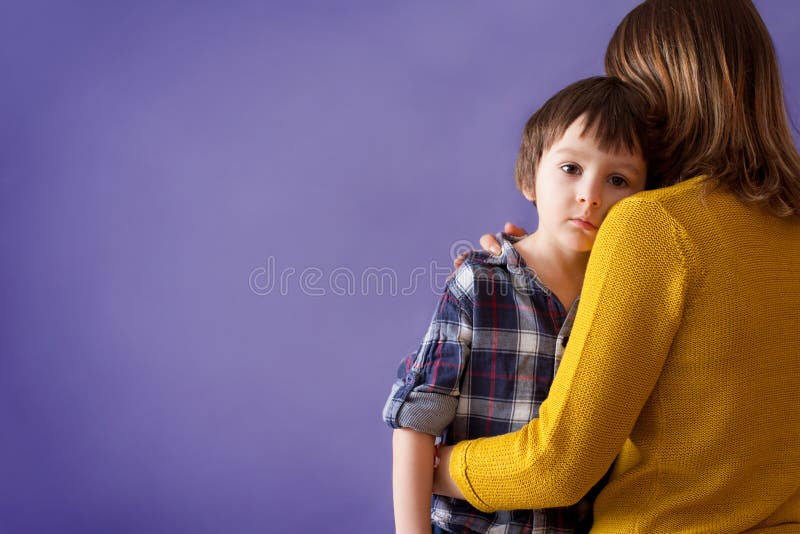 Sad little child, boy, hugging his mother at home. Isolated image, copy space. Family concept stock photography